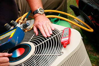 Technician inspecting an AC system in front of a Wisconsin home