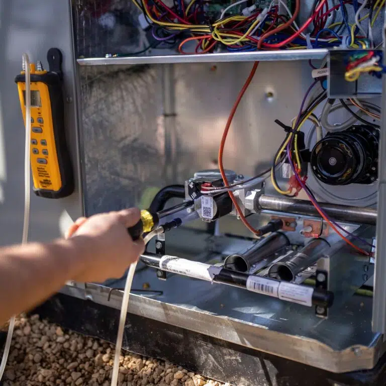 Closeup of HVAC technician working on an AC condenser unit