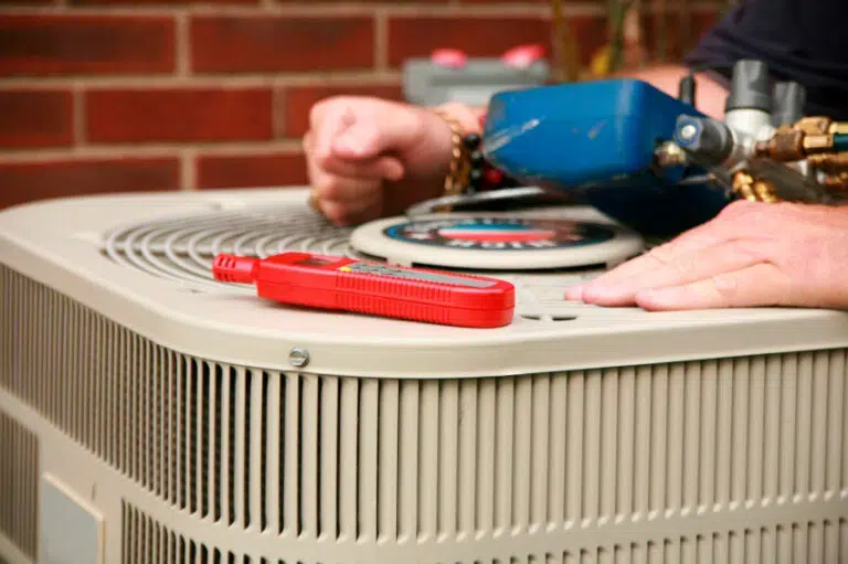 Closeup of HVAC technician working on an AC condenser unit