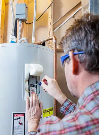 A technician repairing a hot water heater